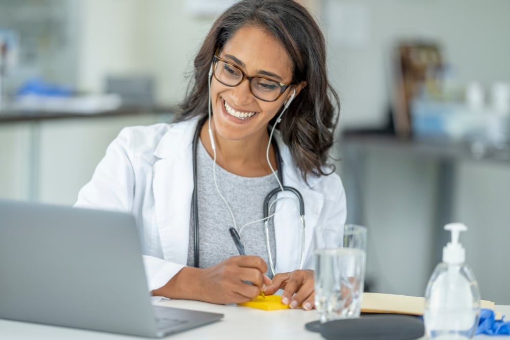 a person in a lab coat writing on a piece of paper